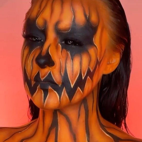 Maquillage Halloween noir et orange avec peinture corps